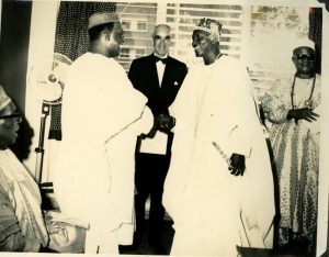 Chief Obafemi Awolowo shaking hands with Oba Oyekan II & Sir Kofo Abayomi seated